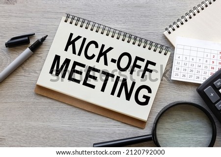 Kick-off meeting Message. open notepad with text on a rustic background. business concept Royalty-Free Stock Photo #2120792000