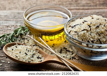 Rice in wooden spoon on kitchen table 