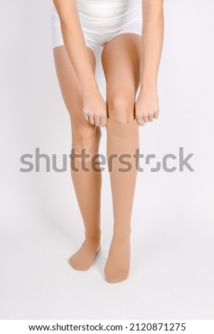 Medical Compression Stockings for varicose veins and venouse therapy. Compression Hosiery. Sock for sports isolated on white background. Beige color socks mock up for advertising, branding, design.