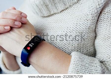 Close up of a woman's high heart rate fitness tracker. Tachycardia after coronavirus. Selective focus. Royalty-Free Stock Photo #2120875739
