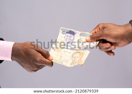 people exchanging naira and cedi Royalty-Free Stock Photo #2120879339