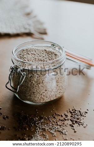 Glass jar with gluten free oats on a table setting with scattered ingredients