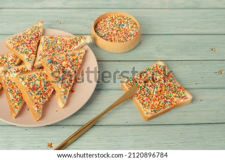Traditional Australian fairy bread on plate isolated on white background. How to make fairy bread, traditional Australian children's party food.
