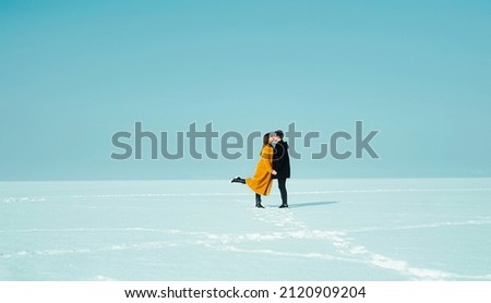 Happy walking couple. In love man and woman walking on the snowy ice. Winter vacation concept. Happy Valentines day concept.