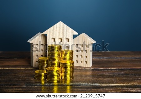 Residential buildings and coins stacks. Municipal budgeting. Tax collection, investments in city development. Profitability of rental business. Valuation of real estate. Property taxes. Content cost. Royalty-Free Stock Photo #2120915747