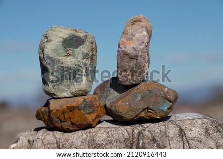 Colorful river stones with brown green orange colours. Blue background.