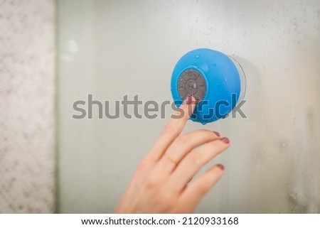 A photo of Woman Using Waterproof Speaker