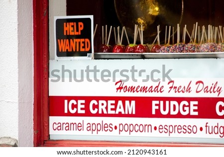 A help wanted sign is seen in a window of a candy shop, as America searches for workers during a covid pandemic