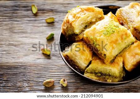baklava with pistachio. turkish traditional delight on a dark wood background. toning Royalty-Free Stock Photo #212094901