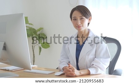 Asian female doctor laughing with a smile Royalty-Free Stock Photo #2120955683