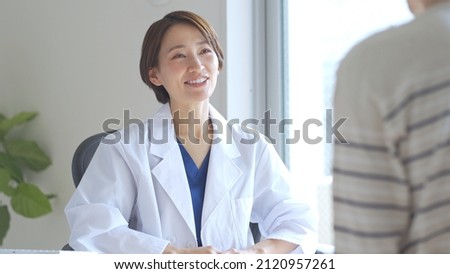 Japanese female medical worker examining a patient Royalty-Free Stock Photo #2120957261