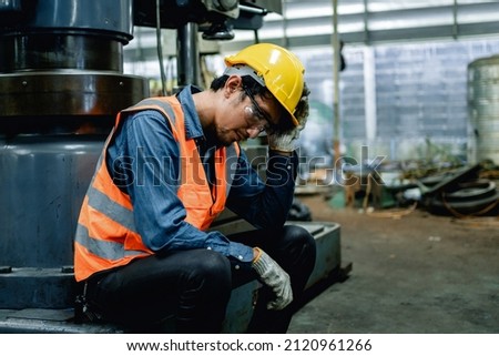 Engineer or Factory worker feeling tired from hard work in a factory, weak, hopeless, burned out, Fired Unemployed Feeling Stressed.