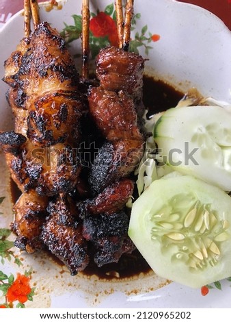 Lamb satay served with soy sauce. picture taken close up
