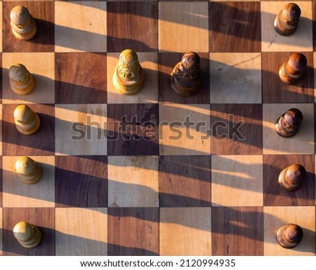 Wooden chess board with wooden pieces with sunlight. Selective focus.
