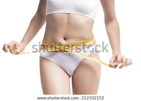 Closeup Of Woman Measuring Her Waistline With Measurement Tape Over White Background