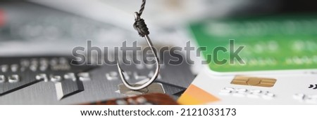 Fishing hook is hooked on plastic bank credit card. Bank scammers concept