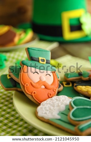 Plate with tasty gingerbread cookies for St. Patrick's Day celebration on table, closeup