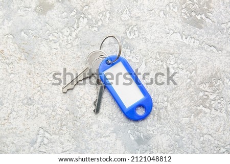 Keys with plastic tag on light background