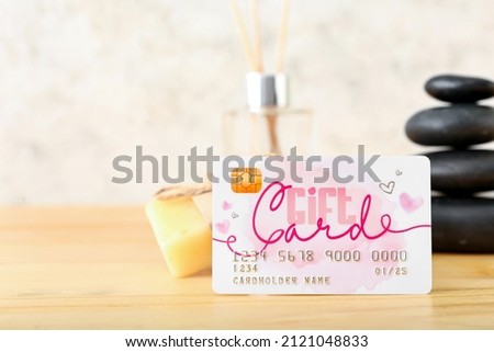 Composition with gift card and spa supplies on wooden table