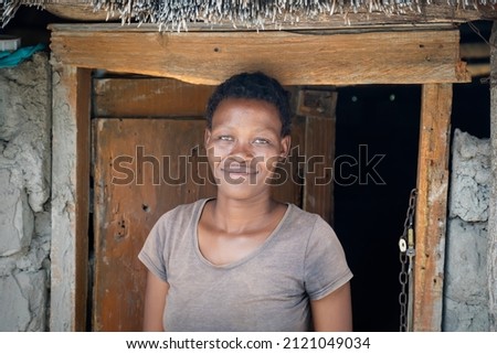 young african woman portrait standing outdoors, village in africa