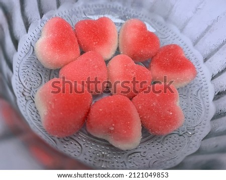 Close up shot of heart shape jelly sugar in glass bowl on isolated white background