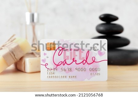 Composition with gift card and spa supplies on wooden table
