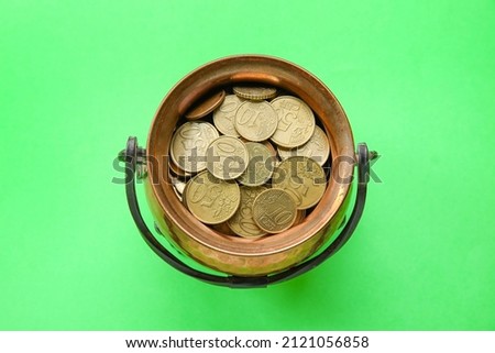 Leprechaun pot with golden coins on color background. St. Patrick's Day celebration