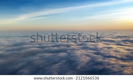 Above the clouds, sunrise or sunset. Clear sky over the fog. View from the plane. Concept, travel, vacation. relax.