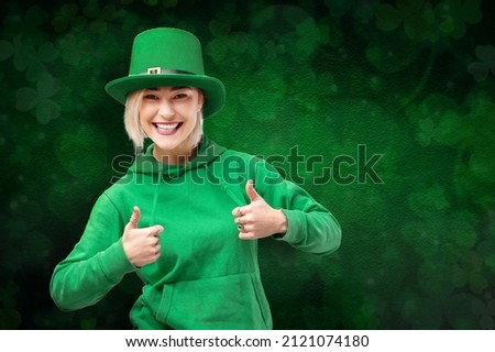 St Patricks day portrait of young woman. Leprechaun model girl on  dark green background with shamrock. St Patricks day celebration