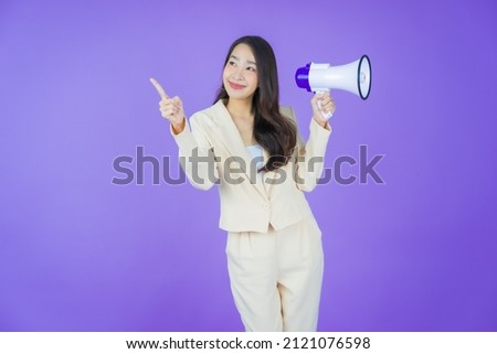 Portrait beautiful young asian woman smile with megaphone on color background