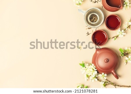 Asian Tea set on stone slate board, ceramic teapot, cups, dried tea and spring branches, tea ceremony, flat lay Royalty-Free Stock Photo #2121078281