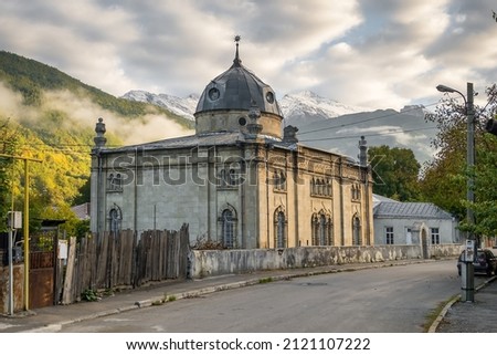 Old Jewish synagogue in Oni village, Racha region, Georgia. Historic synagogue building with snowy peaks of Caucasus Mountains at background. Royalty-Free Stock Photo #2121107222