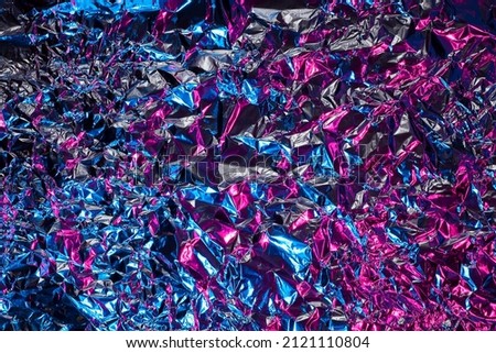Blue and pink aluminum wrinkled foil background. Abstract bright texture reflecting creative gradient. Light neon futuristic colors. Colorful shiny backdrop for screens, website, flyers and brochures