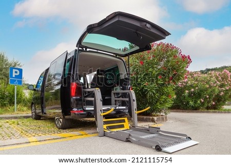 Accessible van with wheelchair lift ramp for person with disability.