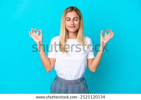 Blonde Uruguayan girl isolated on blue background in zen pose