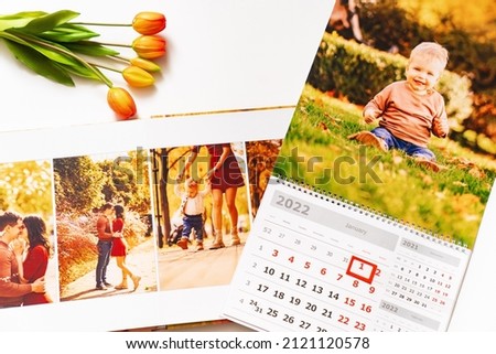 calendar with a photo of the boy and a photobook from a family photo shoot. a memorable gift. printed materials after the photo shoot. services of a professional photographer and printing. Royalty-Free Stock Photo #2121120578