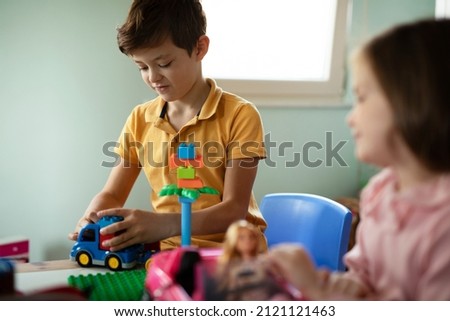 SIster and brother playing with toys at home. Little childs playing with lots of toys indoor