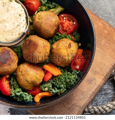 Falafel with hummus on dark background. Mediterranean diet concept. Flat lay, top view, copy space