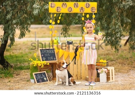 Cute girl with dog near lemonade stand in park