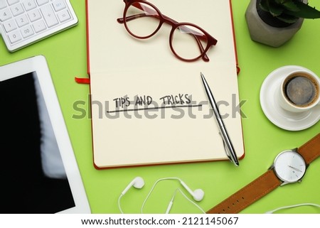 Flat lay composition with notebook on green background. Tips and Tricks