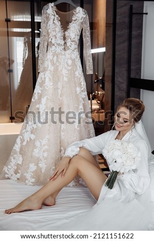 Bride morning. Girl with a bouquet of flowers on the bed. Preparing the bride for the upcoming ceremony. Royalty-Free Stock Photo #2121151622