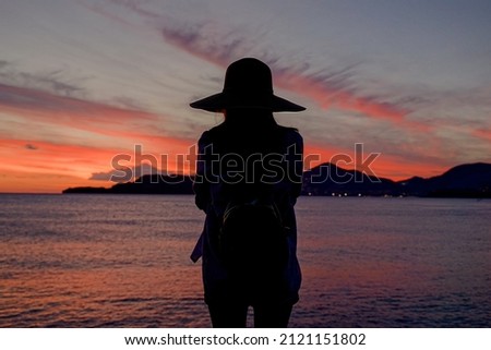 Journey. Silhouette of a woman on the background of the sunset.