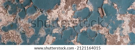 Peeling paint on the wall. Panorama of a concrete wall with old cracked flaking paint. Weathered rough painted surface with patterns of cracks and peeling. Wide panoramic grungy texture for background Royalty-Free Stock Photo #2121164015