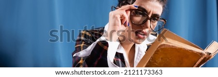 vintage style woman in eyeglasses reading book on blue background, banner