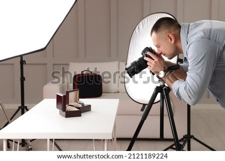 Professional photographer taking picture of expensive wristwatches in studio