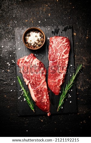 Raw steak on a stone board. On a black background. High quality photo