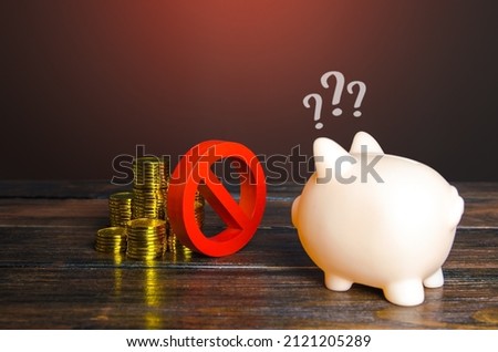 Red prohibition sign NO separates money and piggy bank. Freezing, confiscation, blocking of assets. Suspicious transactions. Sanctions, economic embargo. Savings. Loan disapproval. Bad credit history. Royalty-Free Stock Photo #2121205289