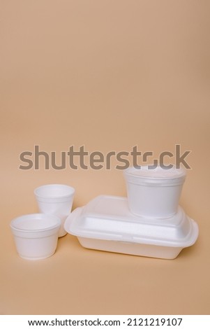 Disposable plastic containers for food on a peach background. Concept of using eco utensils.