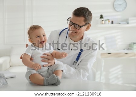 Pediatrician examining cute little baby in clinic Royalty-Free Stock Photo #2121230918