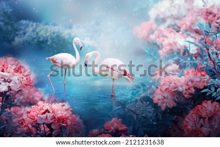 Two flamingos couple standing in lake, fantasy magical enchanted fairy tale landscape with pair of elegant birds, fairytale blooming pink rose flower garden on mysterious blue background in night. Royalty-Free Stock Photo #2121231638